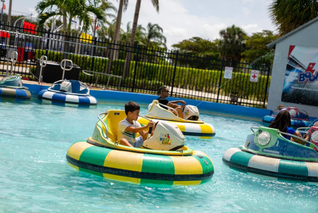Boy smiling on a Bumper Boat At Boomers Boca