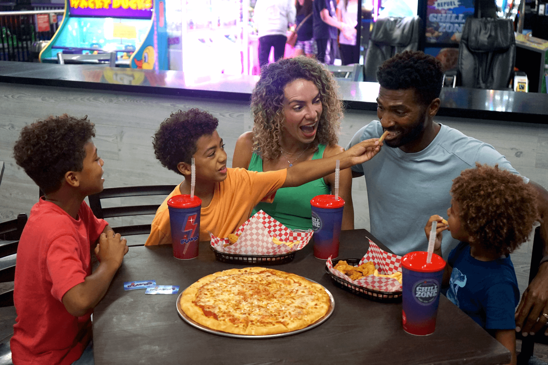 Diverse family eating pizza at the Boomers Chill Zone