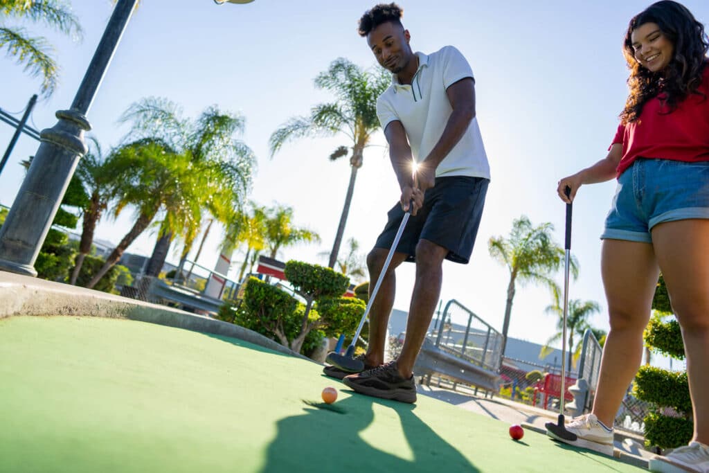 A man plays mini golf