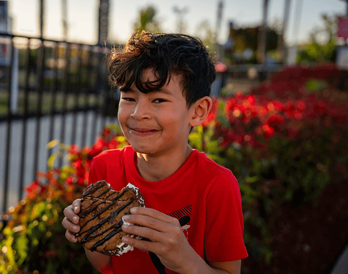boy eating cookie treat at Boomers Park