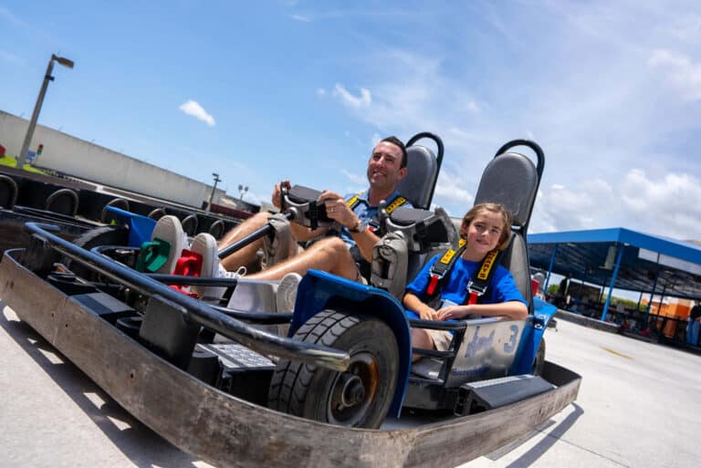 Father and son drive a go kart at Boomers