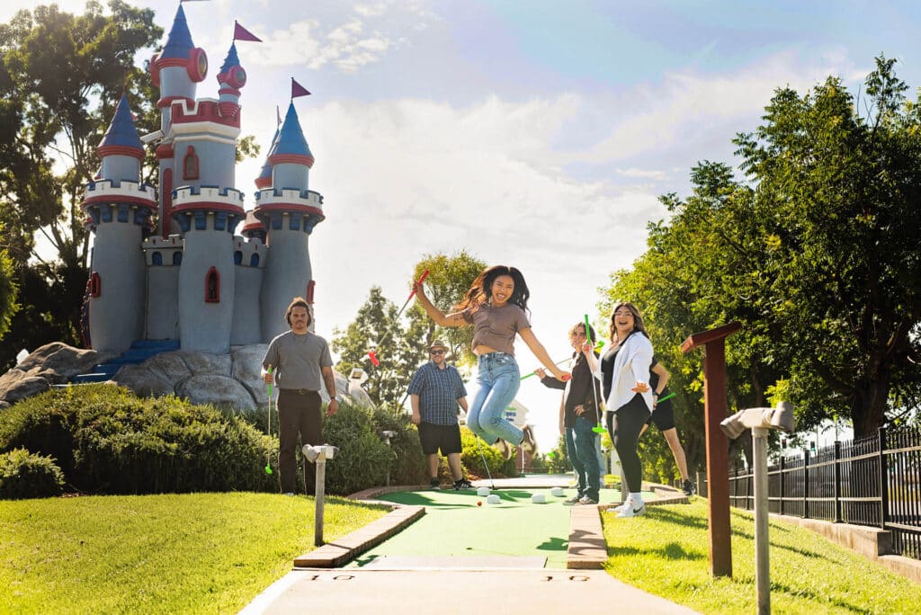 Girl jumping for joy at Boomers Park golf court