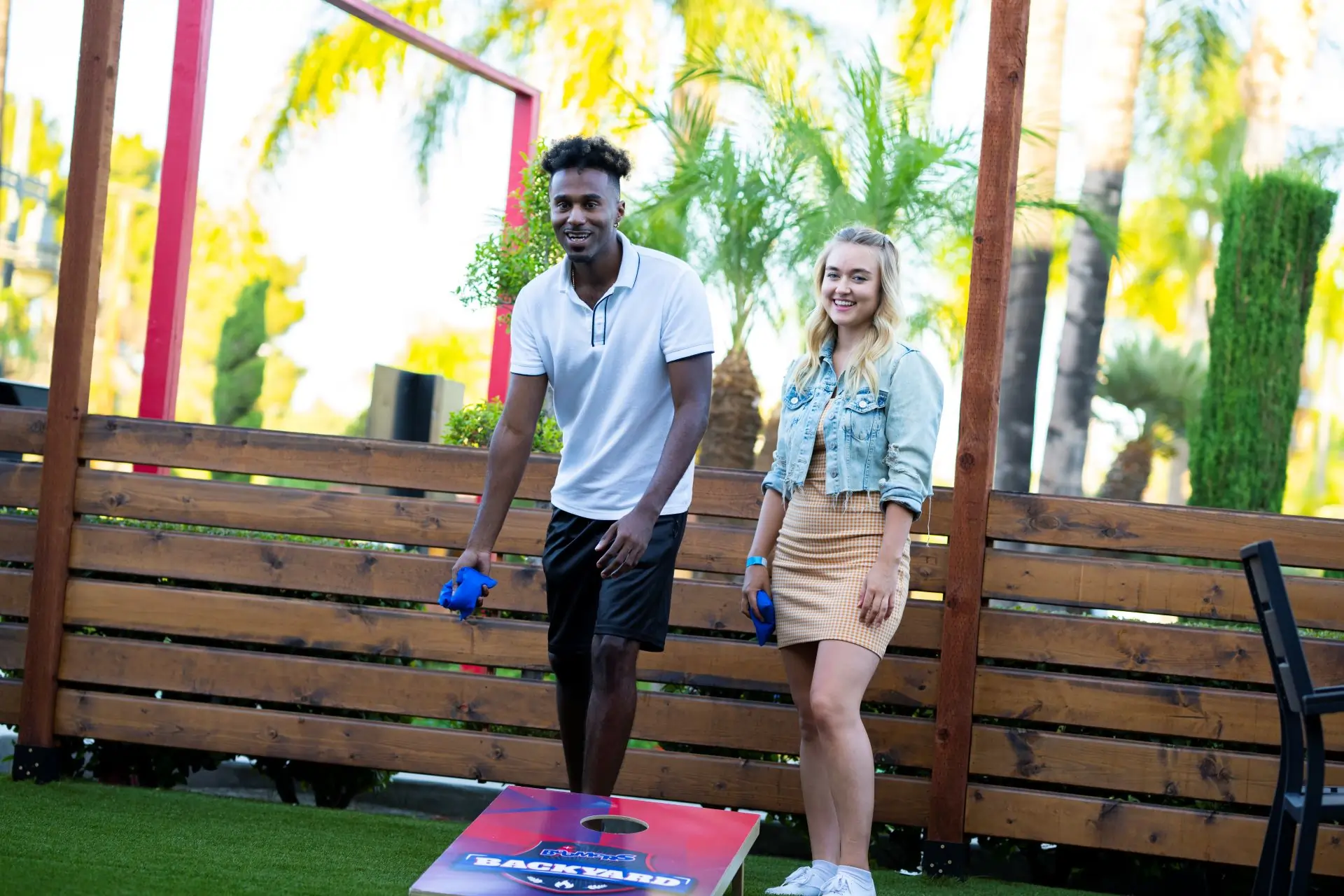Couple playing cornhole Boomers backyard