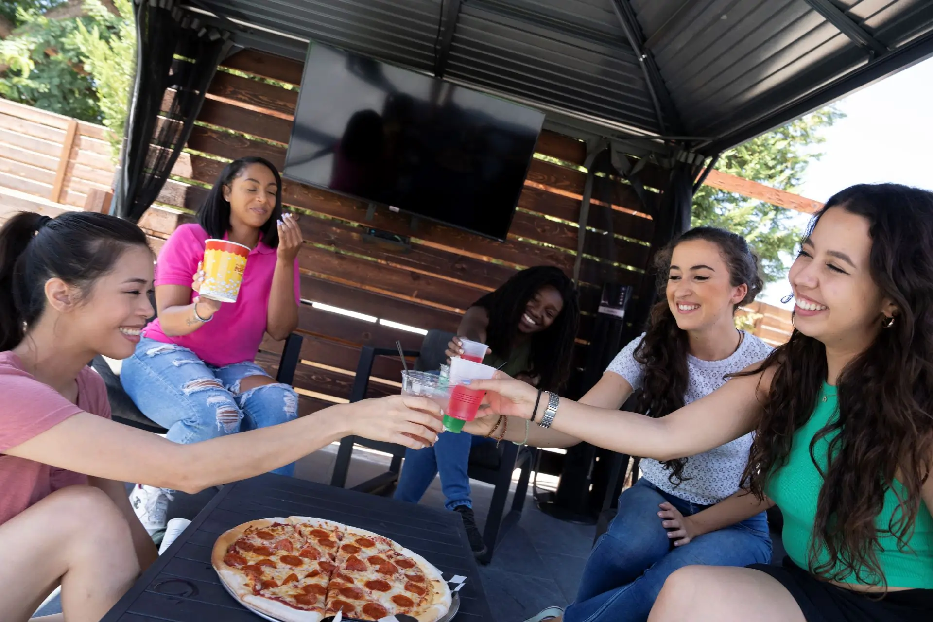 Group with drinks and pizza in cabana