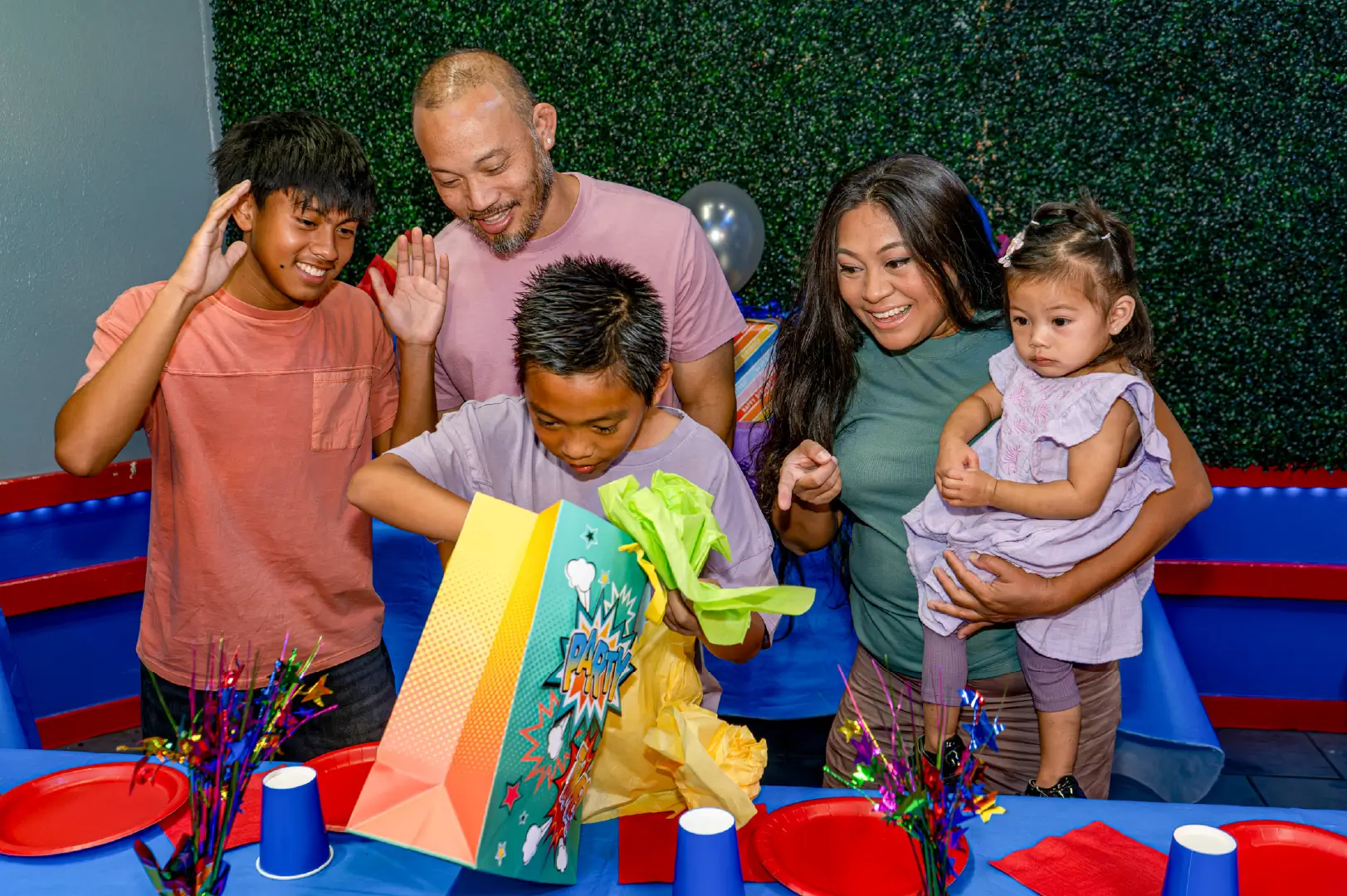 family watch son open gifts at Boomers birthday party