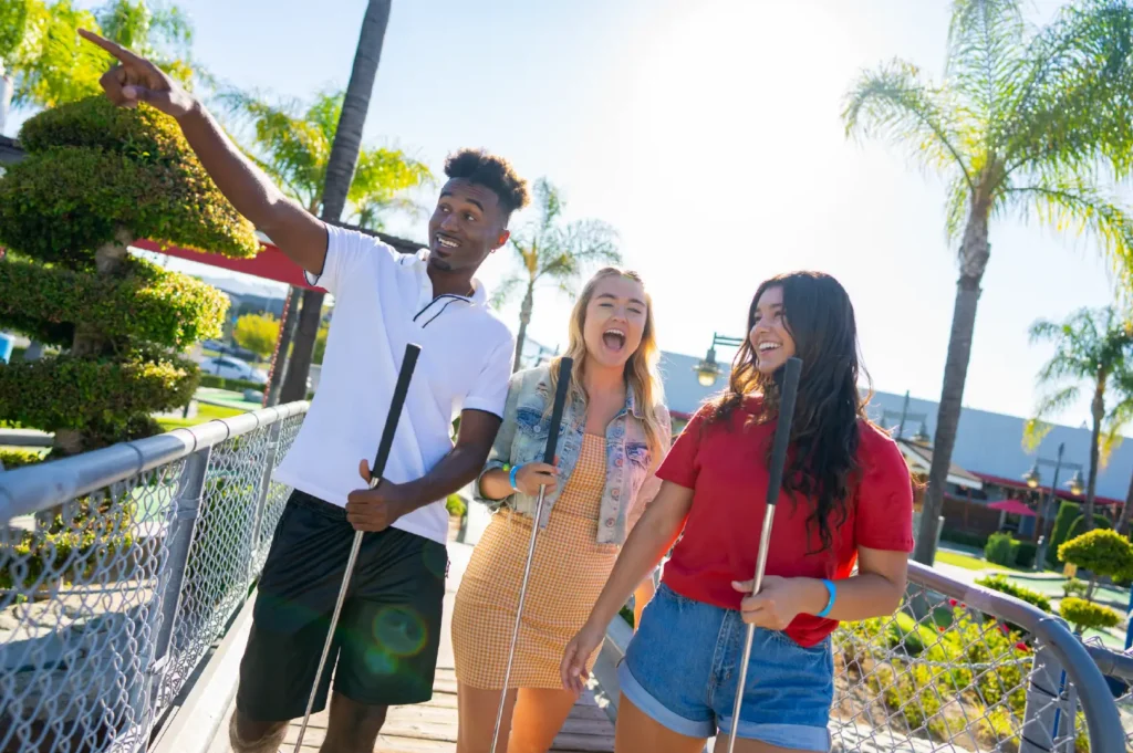 3 Friends play mini golf at Boomers